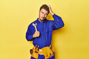 Technician in blue jumpsuit with tools on yellow being shocked, she has remembered important...