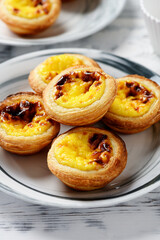 Naklejka na ściany i meble Pastel de nata or Portuguese egg tart. Small tart with a crispy puff pastry crust and a custardy pastry cream filling