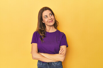 Fototapeta premium Middle-aged caucasian woman on yellow dreaming of achieving goals and purposes