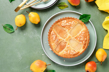 Classic Pear Frangipane Tart (Tarte Bourdaloue). Delicious Autumn and Winter pastry that is full of flavours and texture. top view, green background