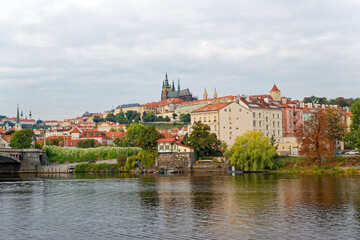 Obraz premium Scenic view of Moldova River with famous old town of Czech City of Prague on a cloudy autumn day. Photo taken October 10th, 2023, Prague, Czech.