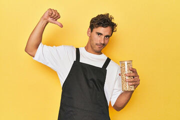 Chef with chickpeas jar on yellow feels proud and self confident, example to follow.