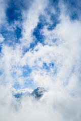 mountain peak covered by sea of cloud with blue sky in the morning at Mount Rinjani, Lombok, Indonesia. Atmospheric mountain nature photo for adventure, trekking, mountaineering concept