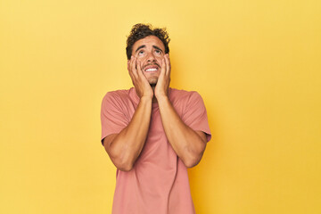 Young Latino man posing on yellow background whining and crying disconsolately. - obrazy, fototapety, plakaty
