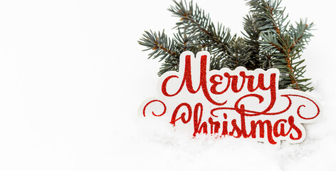 fir tree pine cone branch on snow with small santa claus hat cap,cream white bottle for product advertising,words merry christmas.ice season,winter time.space for text,banner for holiday