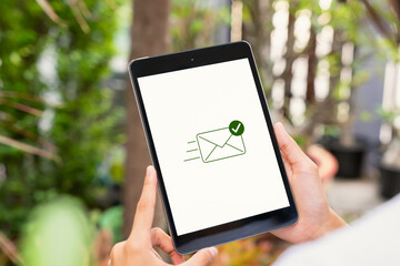 Hand holding digital tablet with showing email send complete.