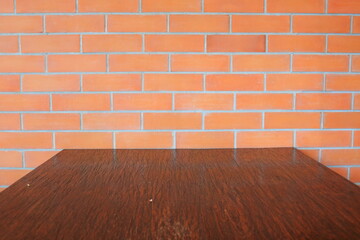 Dark brown wood table and red brick wall.