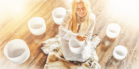 Woman playing on a crystal bowl. Ceremony space.