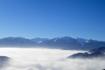 Fototapeta na wymiar landscape of blue sky with high mountains protruding through the white thick fog. AI GENERATE
