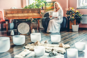 Woman playing on a crystal bowl. Ceremony space.