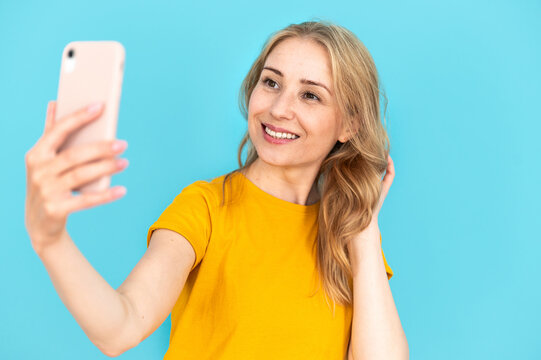 Happy smiling woman holding smartphone and talking at video call