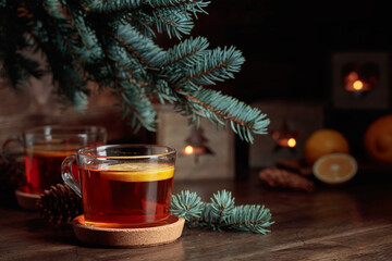 Tea with lemon and small Christmas lanterns on a wooden table.