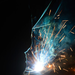 Welder uses torch to make sparks during manufacture of metal equipment