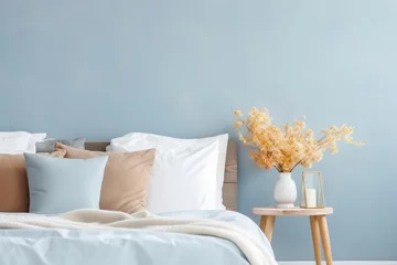 Raamstickers Modern minimalist bedroom interior in blue tones. A bouquet of dry hydrangea and autumn leaves in a vase on the bedside table. © July P