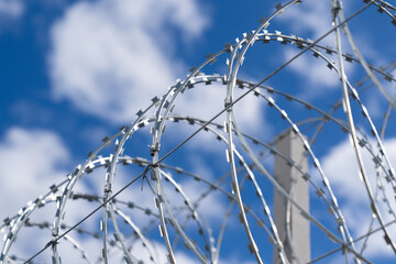 Fence with barbed wire. Metal barbed wire. Barbed wire security fence. Barbed wire close-up. Border with barbed wire.