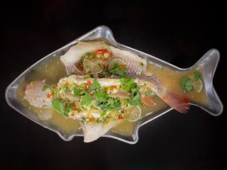 Food and cuisine concept. Thai dish menu. Steam lime fish served on a table.
