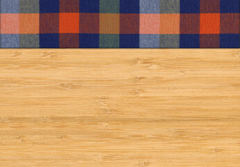 Colourful plaid napkin on bamboo wooden floor table or cutting board