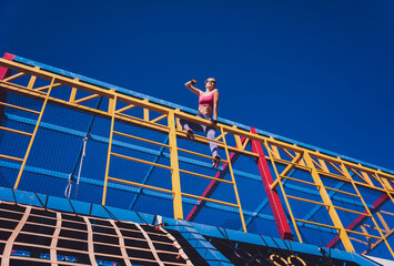 Athletic young woman working out and climbing at the training camp.