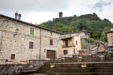 a street with traditional houses with a view to the castle in Radicofani, province of Siena, Tuscany, Italy