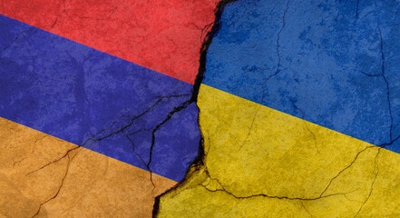 Armenia and Ukraine flags, concrete wall texture with cracks, grunge background, military conflict concept