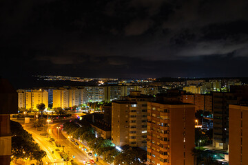 Aerial view street in Alicante, Spain, night time. Road with palm trees and cars, night photos.