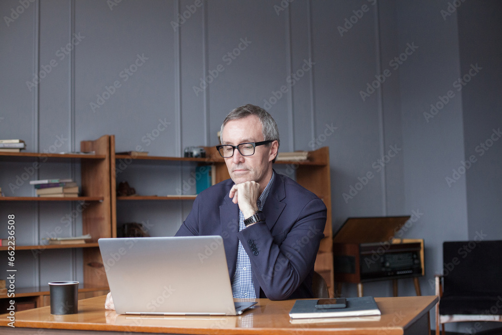 Wall mural middle aged man using laptop indoor.