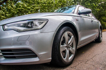 A gray car close-up stands on an asphalt road