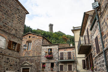 a street with traditional houses with a view to the castle in Radicofani, province of Siena, Tuscany, Italy