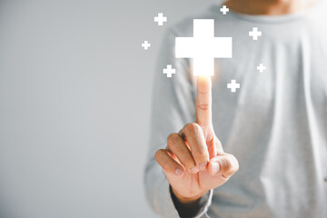 Businessman hand touches a virtual plus sign, signifying positivity. Implies more benefits, strategic thinking, and a positive mindset. Business and success concept. positive thing