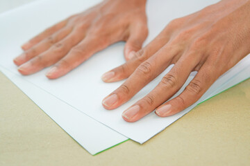 hands with white paper. folds a sheet of white paper. A writing blank. A white piece of paper