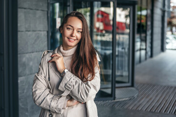 Portrait of a happy young woman against the background of an office building