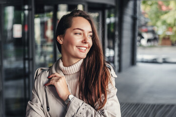 Portrait of a happy young woman against the background of an office building