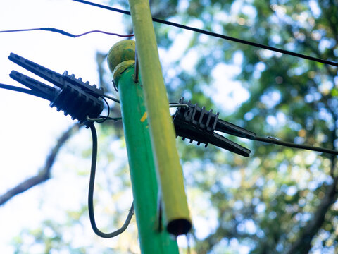 a series of electric cable, a series of electric cables for garden lights mounted on a support pole with a combination of green and yellow.