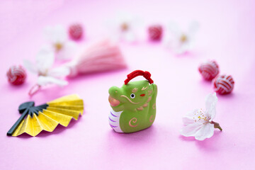 日本の正月　サクラの花と干支の辰とタッセルとお金色の扇（ピンクバック）