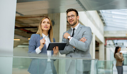 Business couple holding digital tablet and discussing company strategy