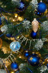 Obraz na płótnie Canvas Golden and blue baubles on christmas tree for background. New Year concept.