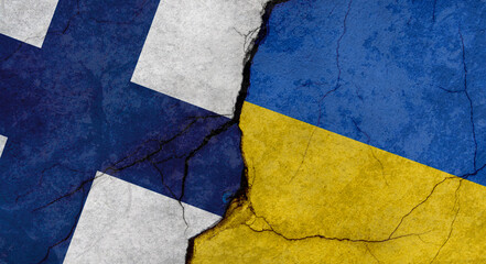 Flags of Finland and Ukraine, texture of concrete wall with cracks, grunge background, military conflict concept