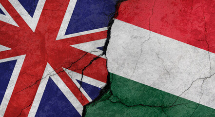 Great Britain and Hungary flags, concrete wall texture with cracks, grunge background, military conflict concept