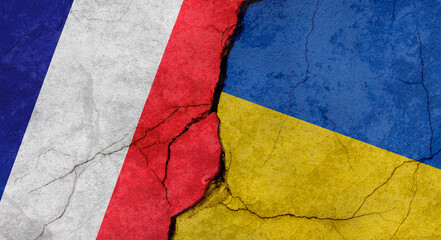 France and Ukraine flags, concrete wall texture with cracks, grunge background, military conflict concept