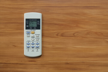 a white air conditioner remote control on a wooden table. with copy space