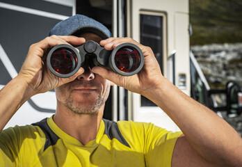 Spotting Wildlife Using Binoculars While Staying in Front of RV Camper Van