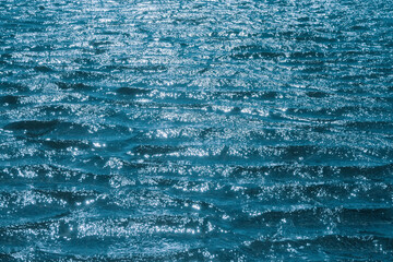 blue water surface with sun glare. marine background, texture