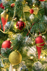 Red and golden baubles on christmas tree for background. New Year concept.
