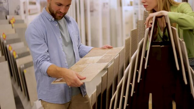 Young couple at the building market choosing tile