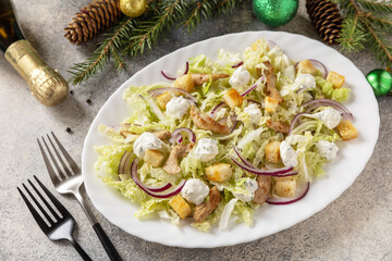 Christmas appetizer. Christmas New Year salad chinese cabbage, feta cheese, chicken and croutons on the festive table.