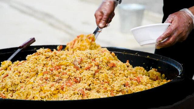 Cooking traditional oriental pilaf in a cauldron in nature