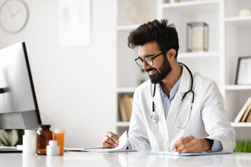 Indian Doctor Engaged in Work at Clinic Computer - obrazy, fototapety, plakaty