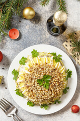 Christmas appetizer. Christmas New Year salad with potatoes, liver and nuts on the festive table. View from above.