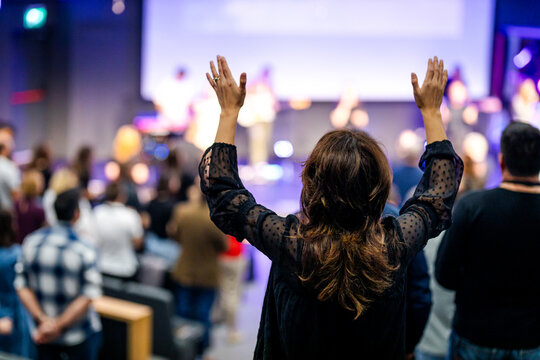 Woman with her hands raised to prayer in the church