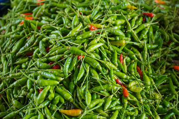 Photo of a pile of green and red cayenne pepper at the supermarket. a traditional market in...